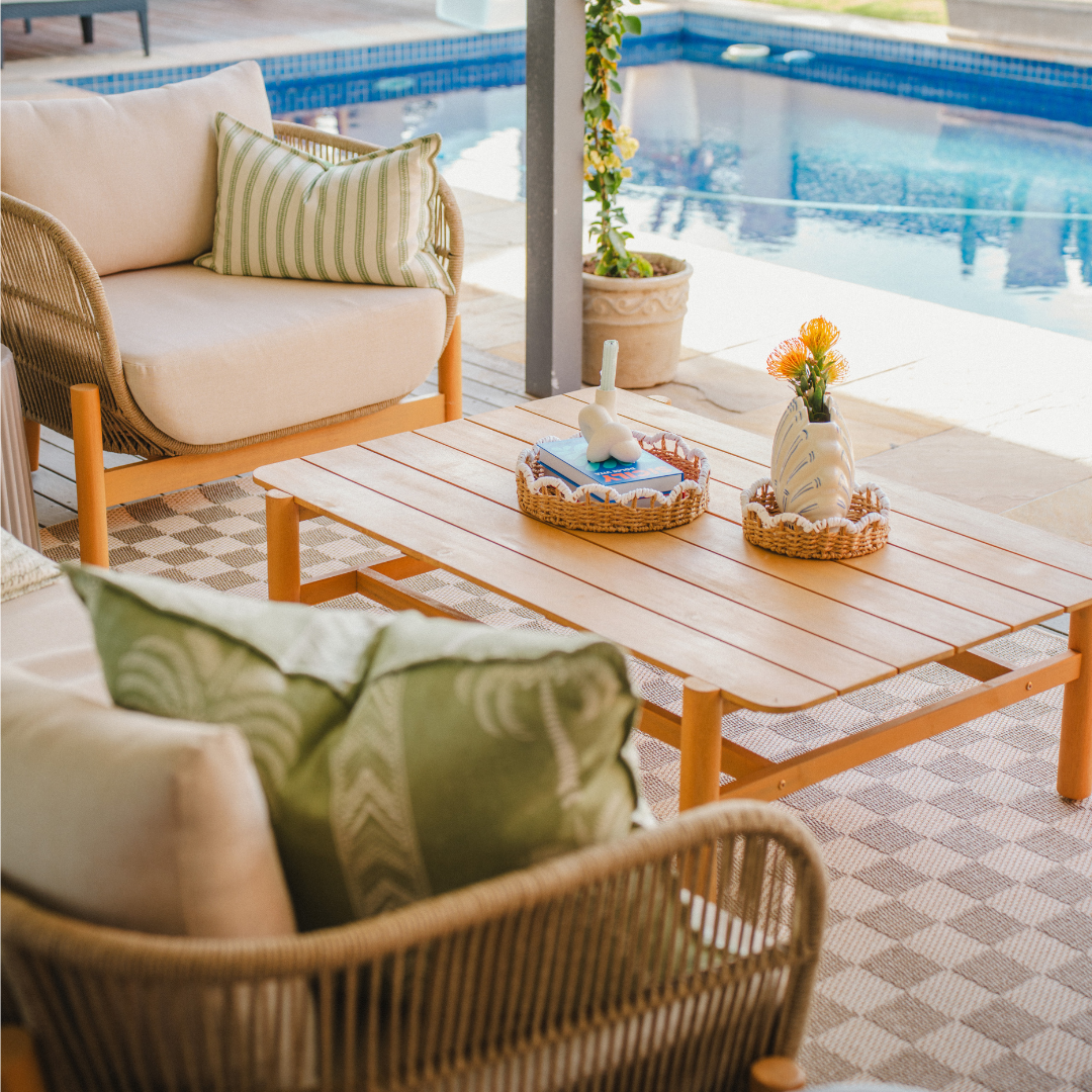 Outdoor chairs in South Africa styled on a modern patio with wooden coffee table and poolside setting.