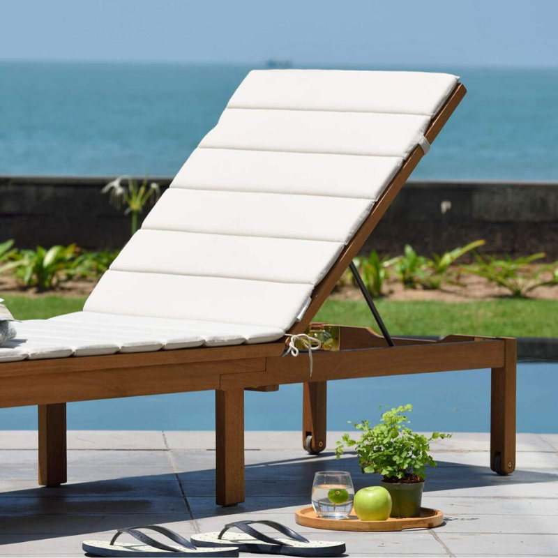 Elegant pool loungers styled on a wooden deck overlooking the ocean for refined summer relaxation