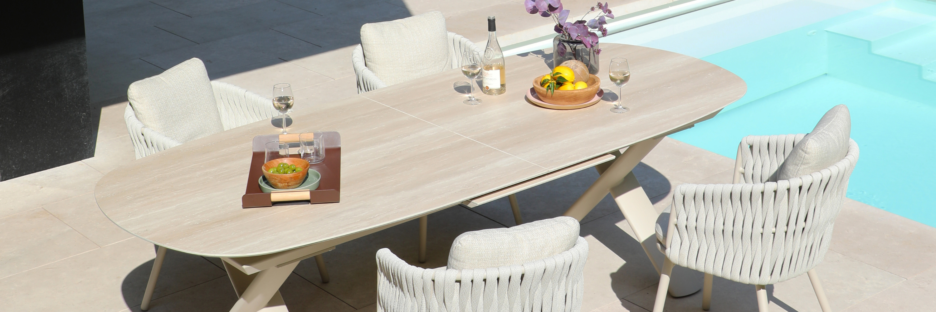 Luxury outdoor dining furniture set with modern dining table and chairs beside a pool in a South African outdoor living space