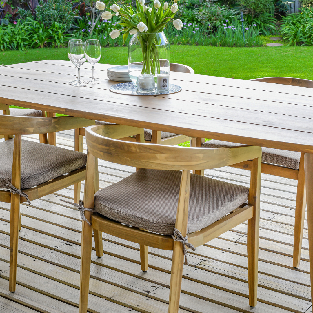 Outdoor dining table and wooden chairs with seat cushions