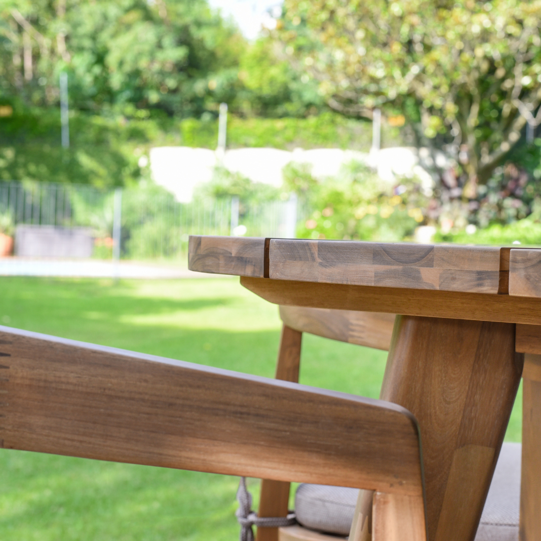 Close-up of solid wood outdoor dining table edge and chair arm