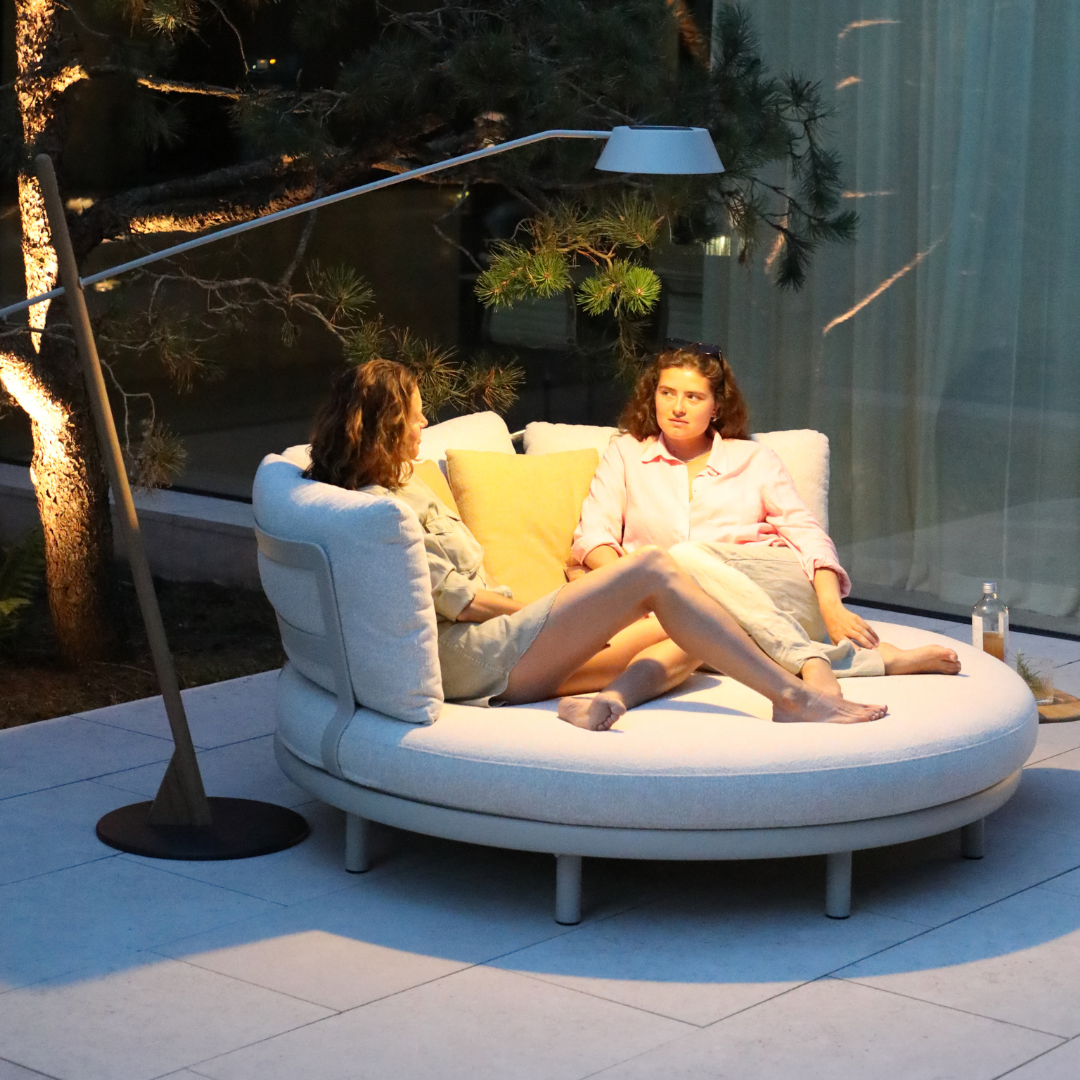 Cloud Island Outdoor Daybed illuminated at night on a patio