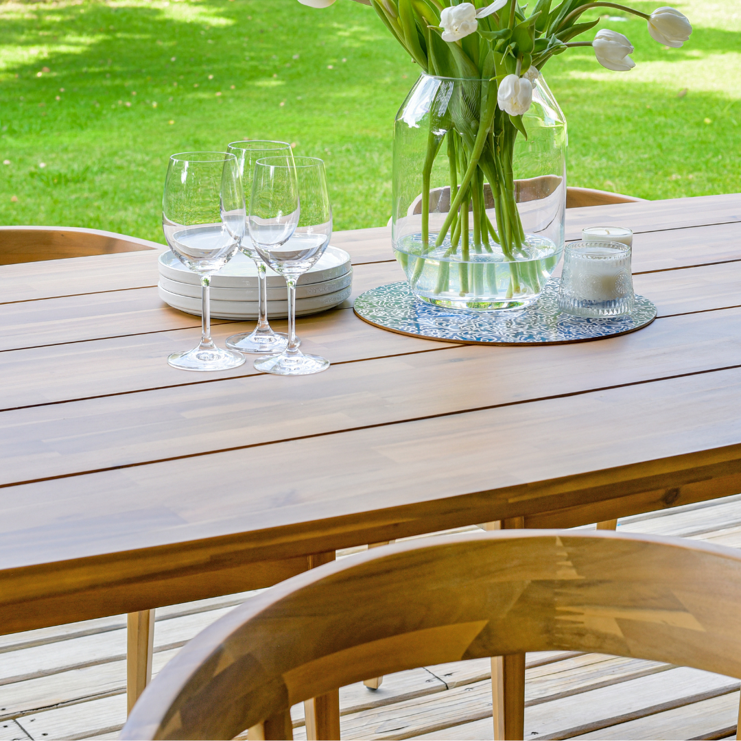 Wine glasses and a vase placed on a wooden table - close up image