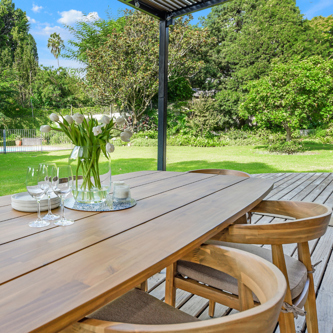 Large wooden outdoor dining table set on covered patio