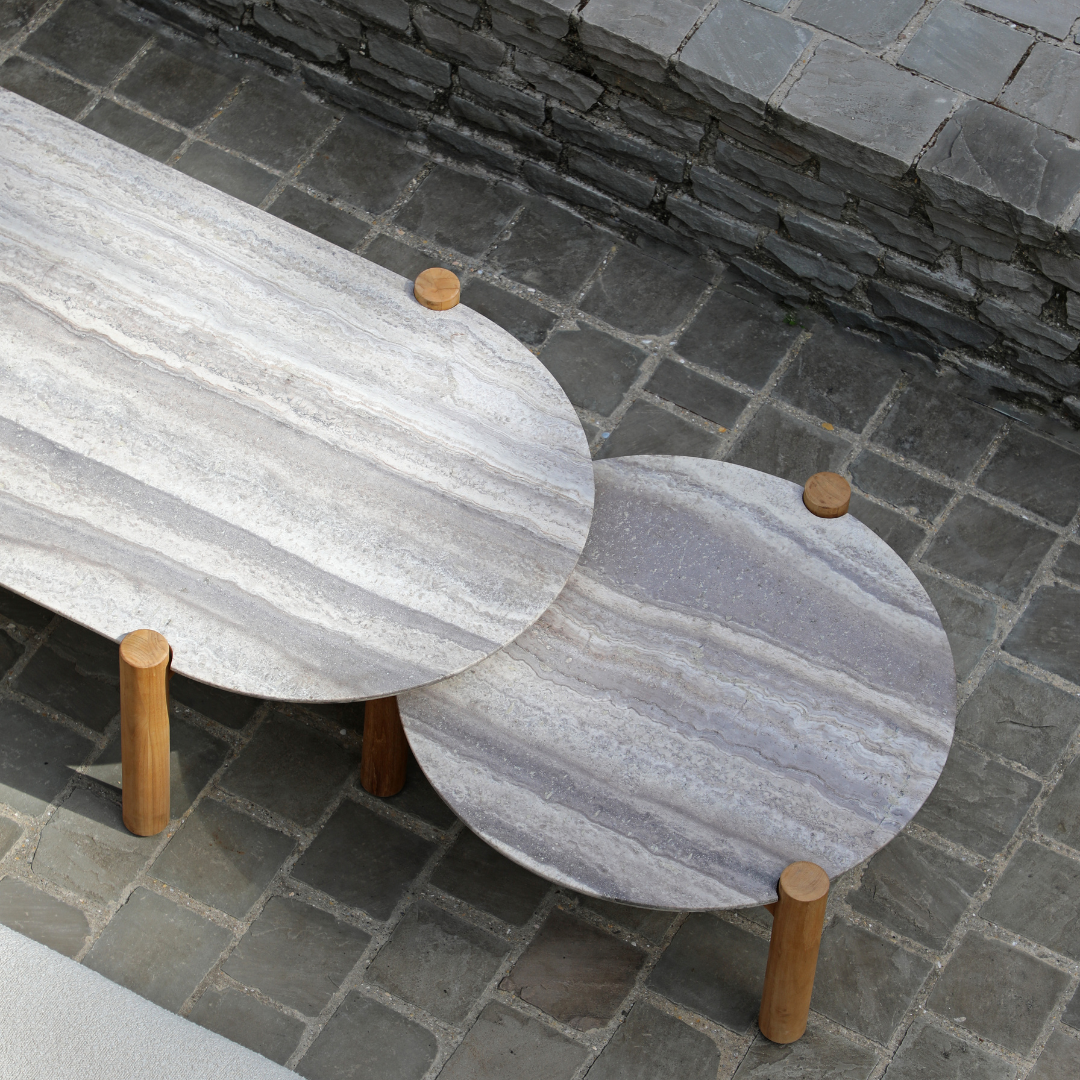 Modern outdoor sofa with sculptural patio coffee table and side tables on contemporary terrace.
