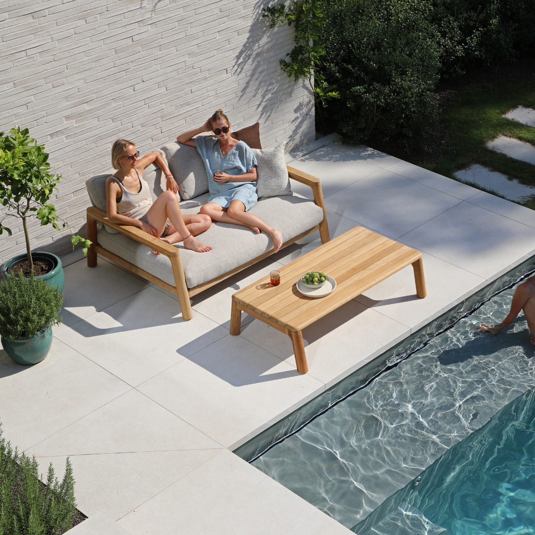 Poolside teak outdoor furniture featuring a comfortable teak sofa and coffee table for relaxed outdoor living.